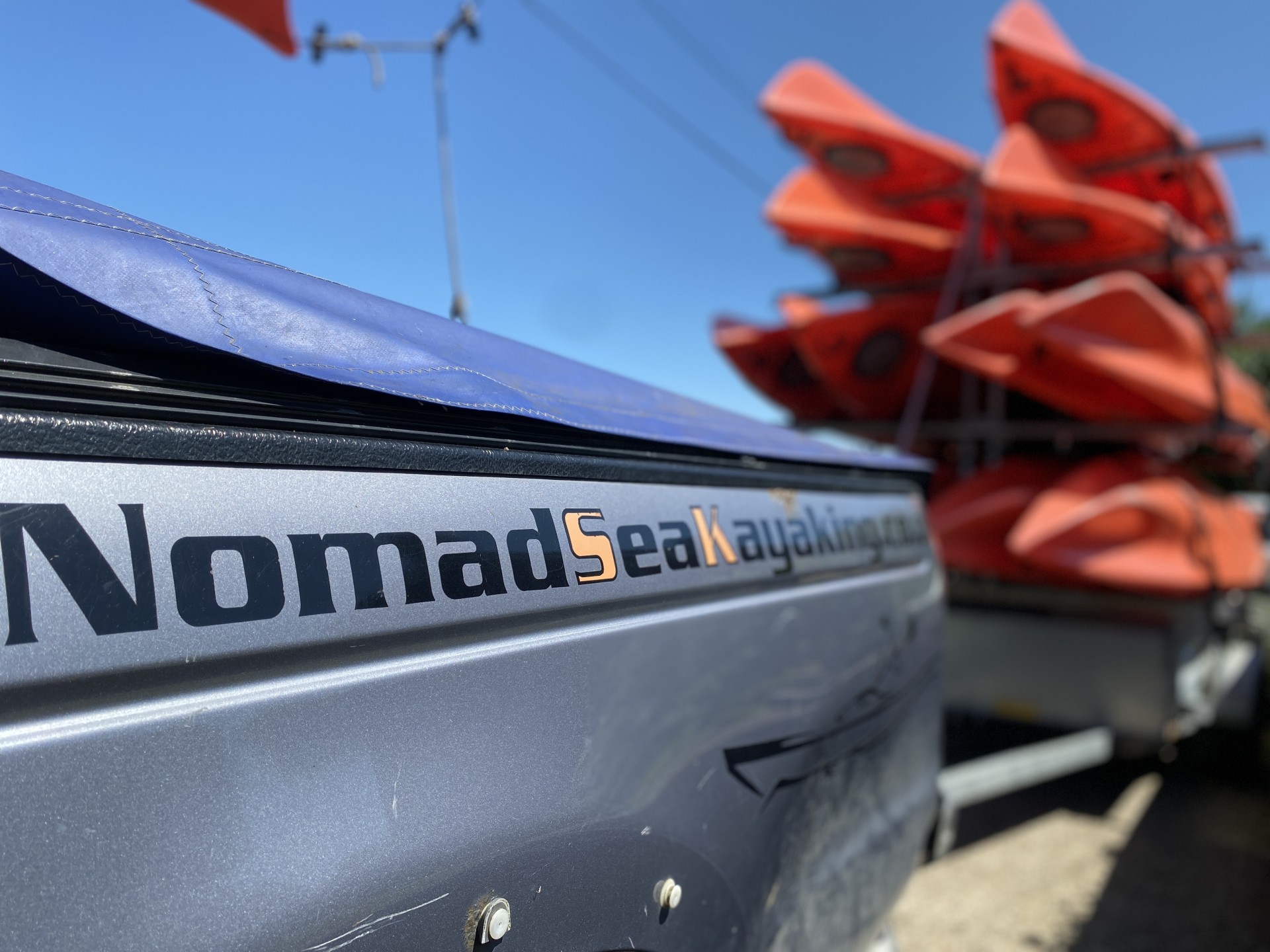 NOMAD Sea Kayaking pulling a large trailer of sea kayaks.