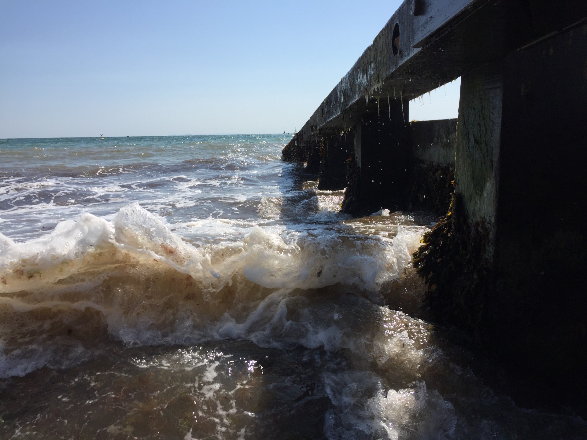 Water splashing up against the pier in Swanage Bay, Dorset.