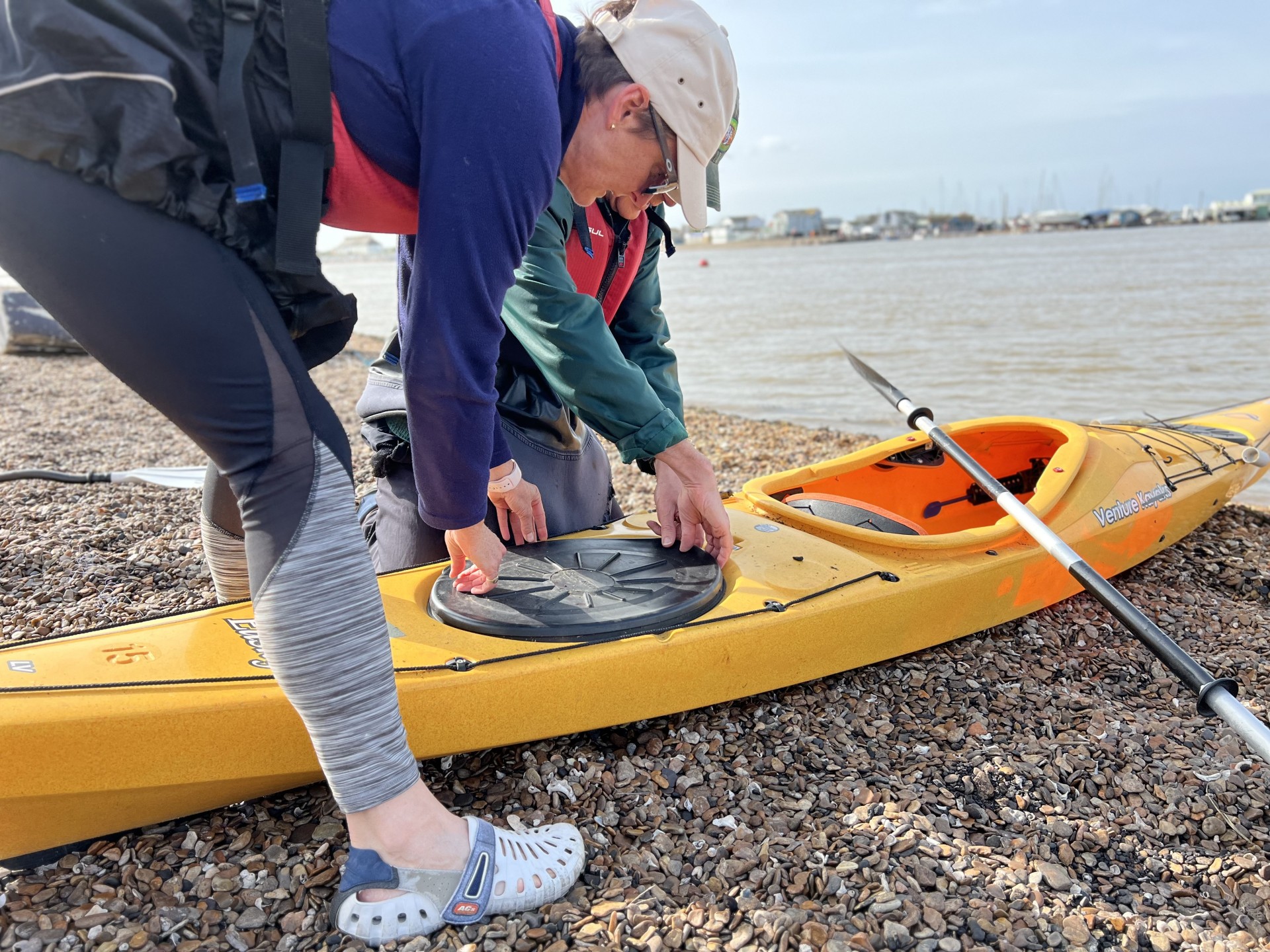 Kayakers packing their sea kayak with NOMAD Sea Kayaking.