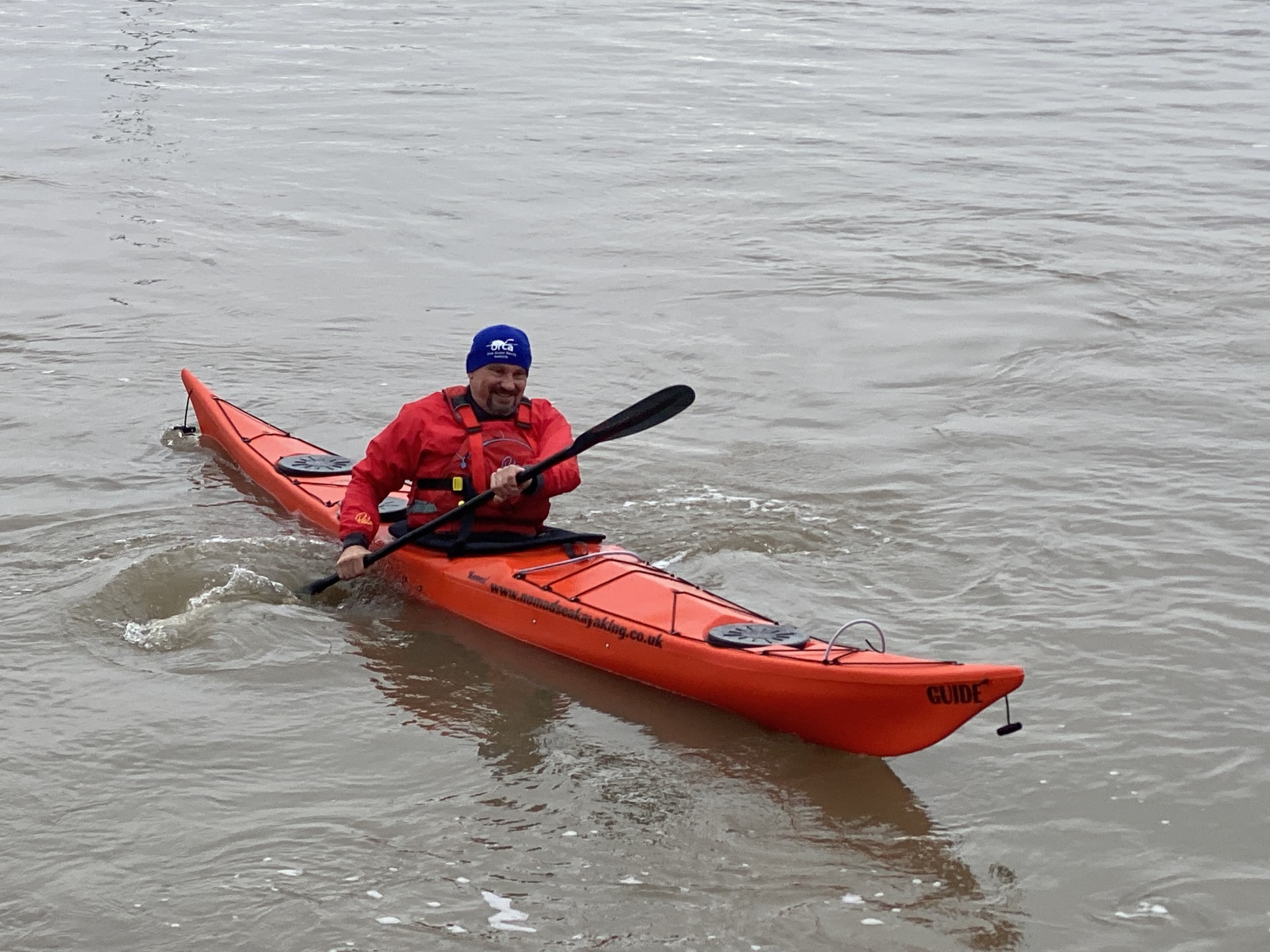 Sea kayaker in a red sea kayak.